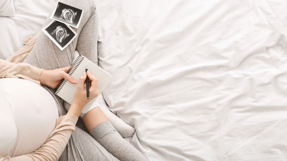 femme-enceinte-lit-ecriture